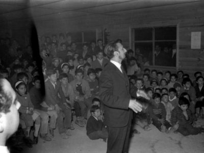 Mario Baeza dirigiendo el Coro UTE en una escuela