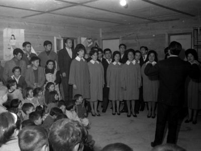 Mario Baeza dirigiendo el Coro UTE en una escuela